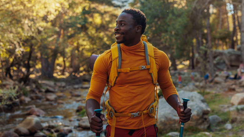 A young African American man hiking in the woods.