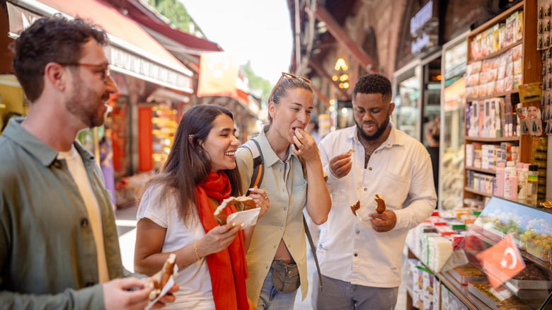 A group of friends enjoys street food at a vibrant market
