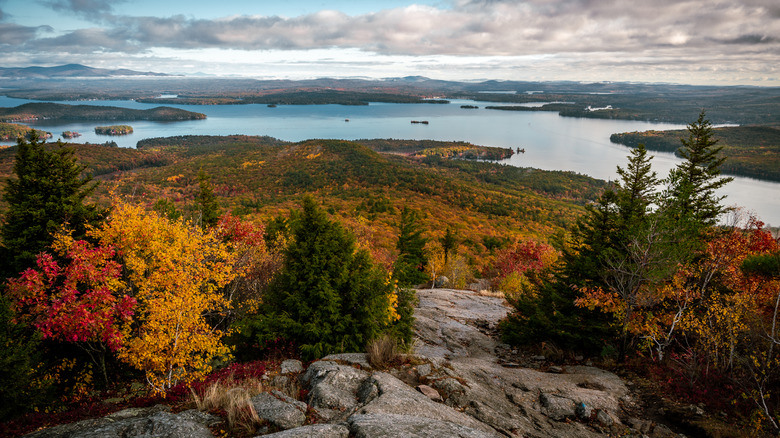 A rocky summit looks out over Lake Winnipesaukee in fall